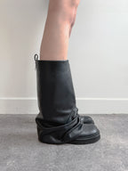Black leather boot on a plain background