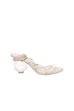 Beige high-heeled shoe with a clear glass sphere on a white background