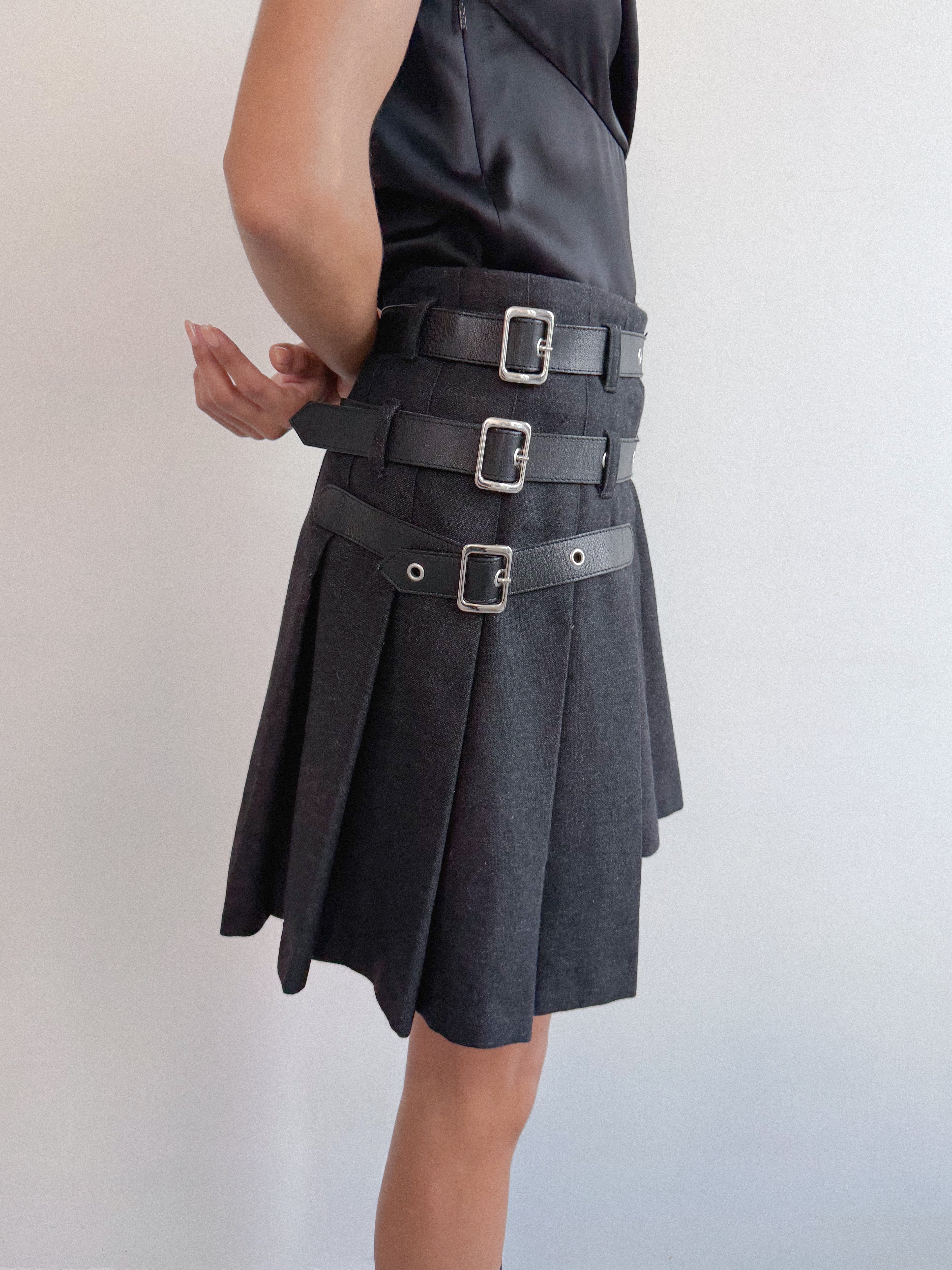 Black skirt with silver buckles on a plain background