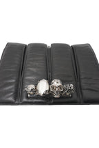 Black leather clutch with skull and gemstone design on a white background