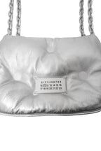 Silver quilted handbag with a visible brand label on a white background