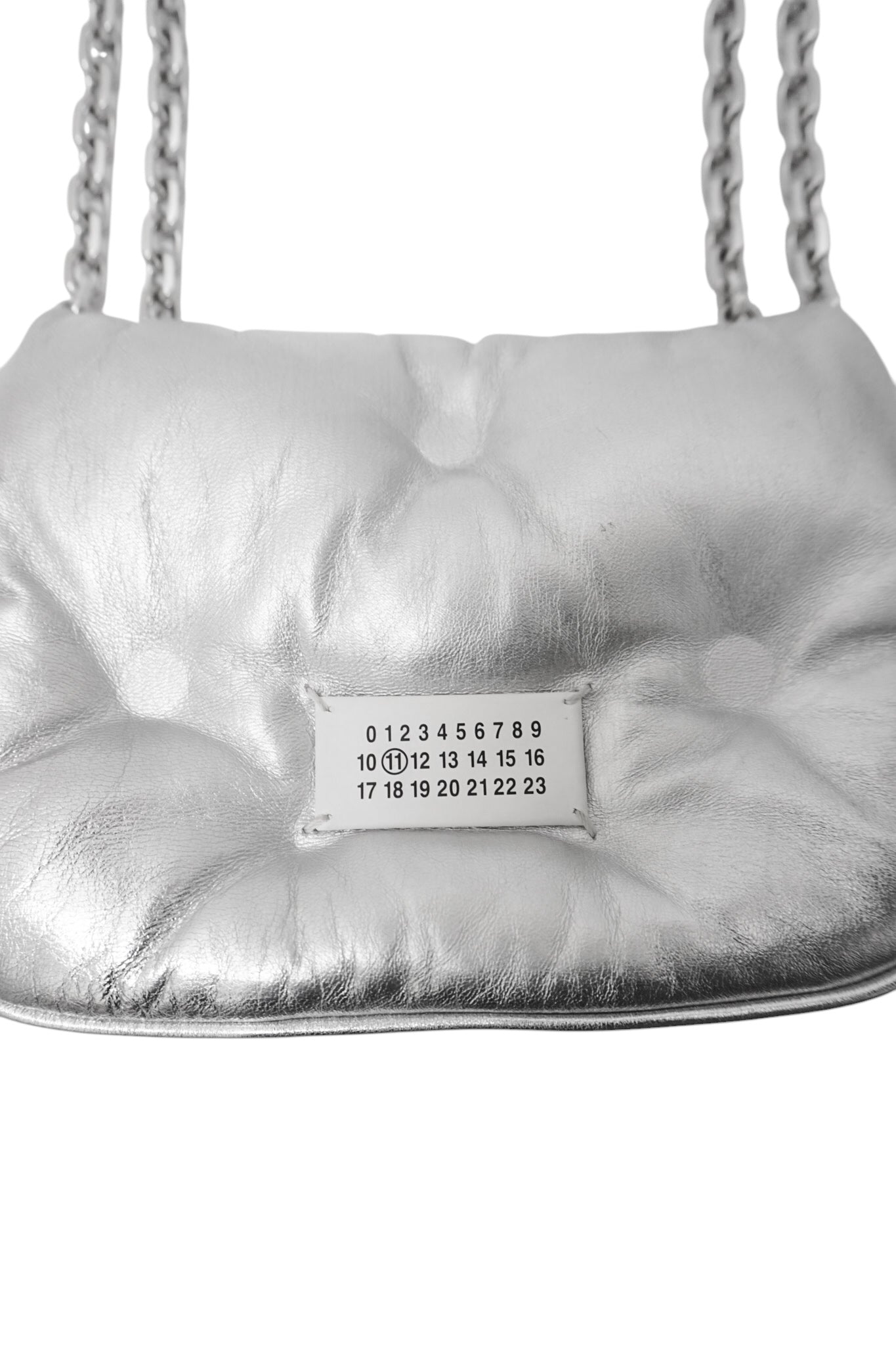 Silver quilted handbag with a visible brand label on a white background