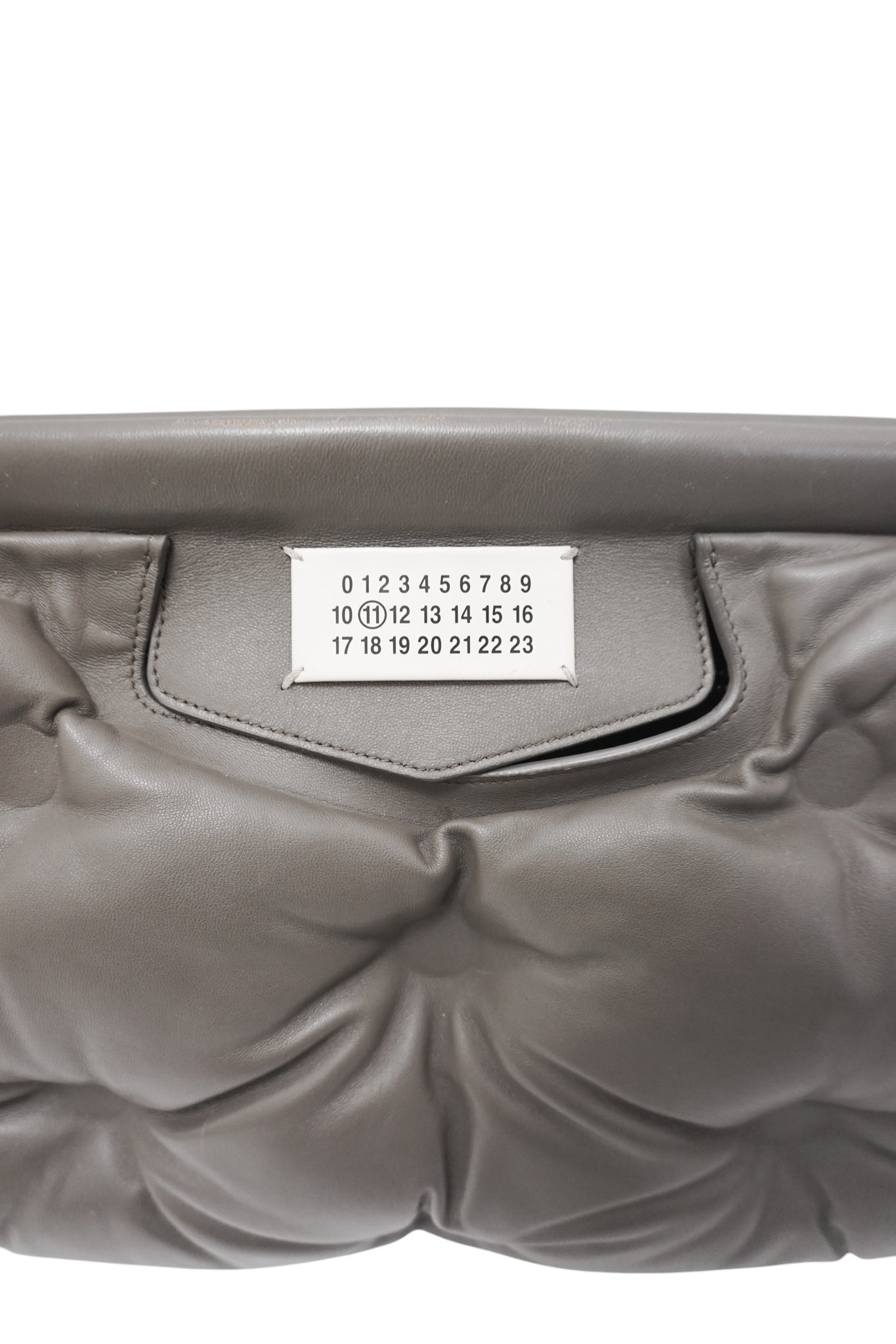 Gray quilted handbag with a visible brand label on a white background