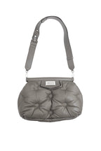 Gray quilted handbag with a strap on a white background