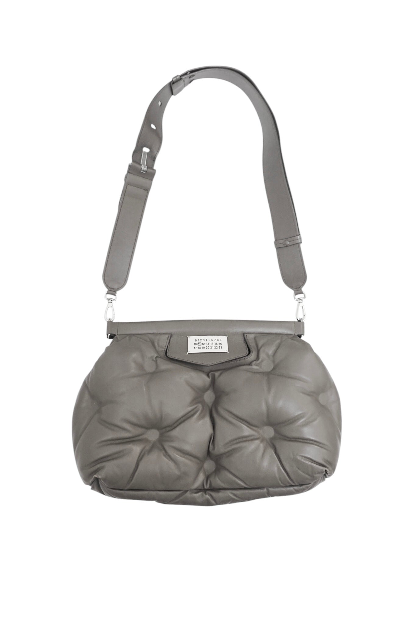 Gray quilted handbag with a strap on a white background