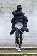 Person wearing a large black puffer coat in an urban setting