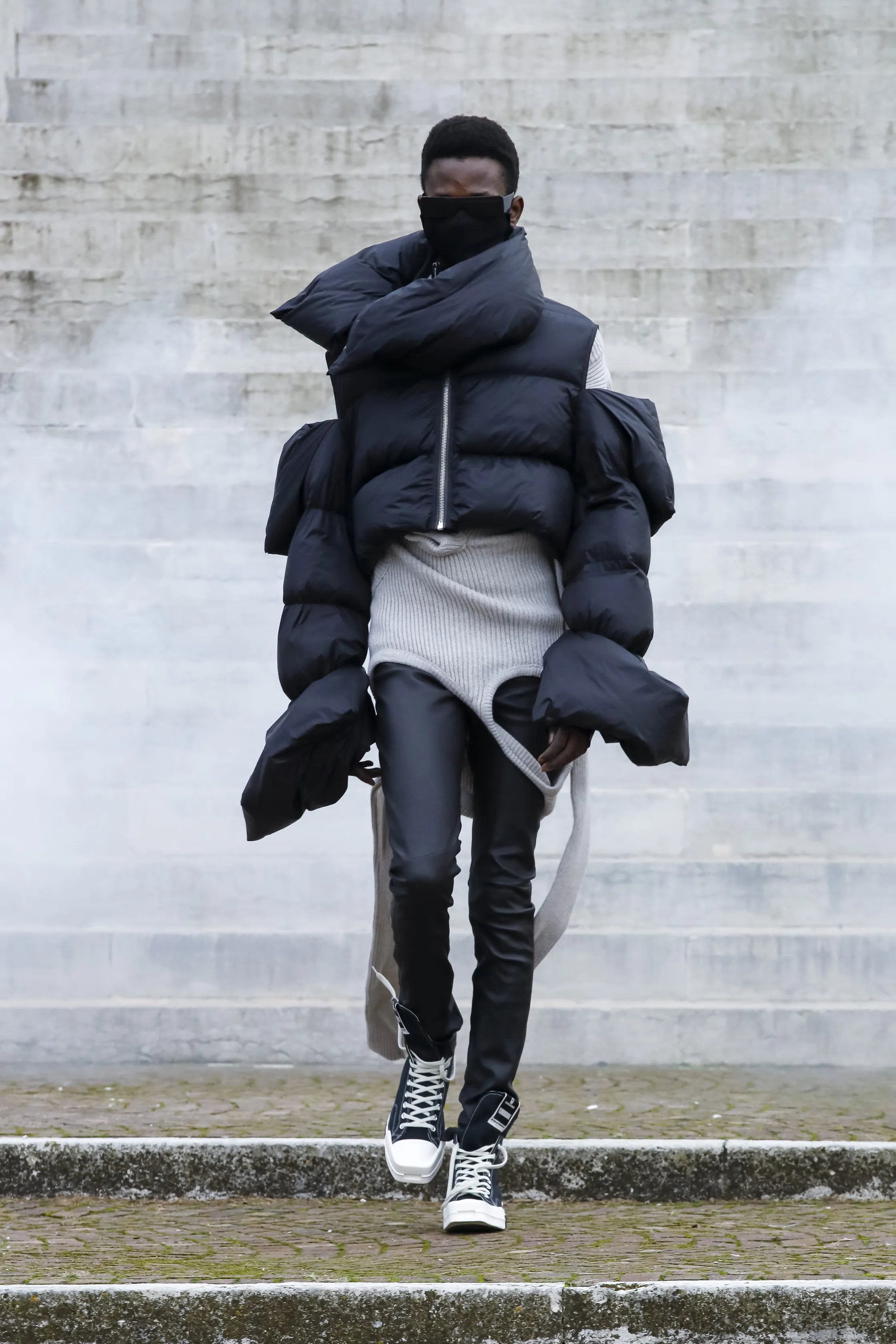 Person wearing a large black puffer coat in an urban setting