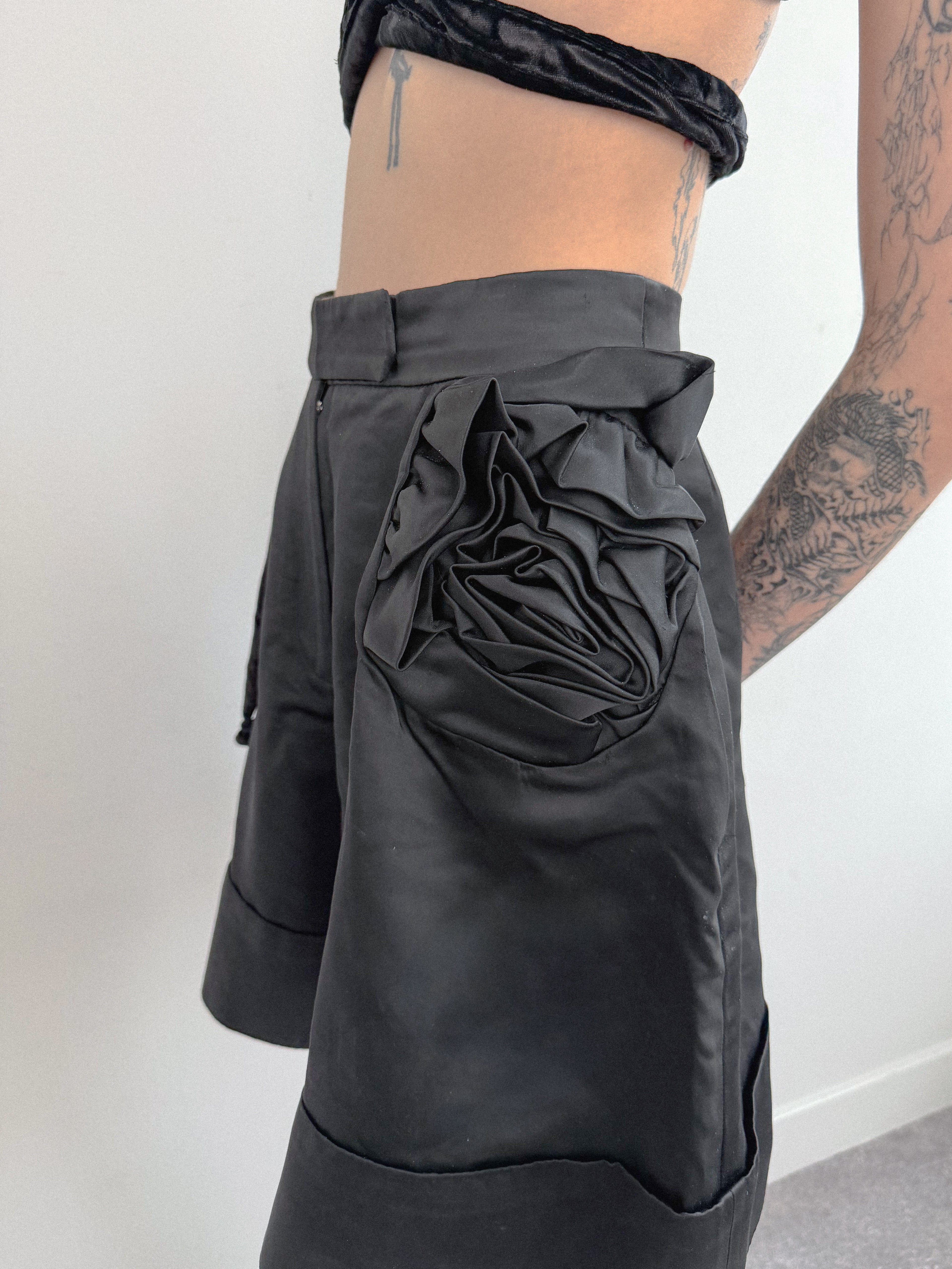 Black shorts with a large pocket design worn by a person against a white background