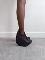 Person wearing black mesh shoes on a plain background